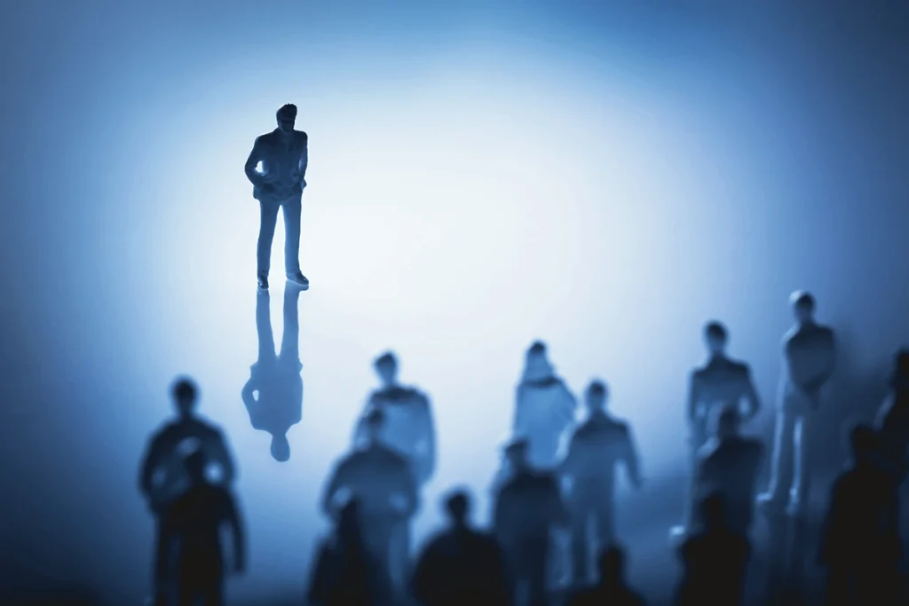Einzelne Person steht einer Gruppe gegenüber – Symbolbild für soziale Ängste