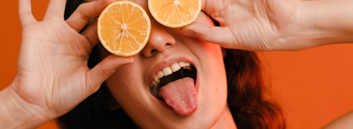 Mutmacher für Psychos - Projekt von Dr. Thomas Graf Verrückte oder lustige Frau hält Orangenscheiben vor den Augen und zeigt die Zunge als Bild eines Psychos